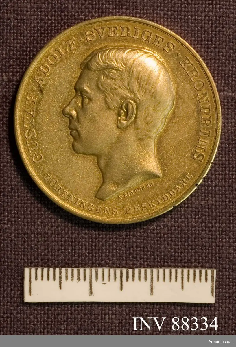 Grupp M II. Inskription: "Gustaf Adolf Sveriges Kronprins. Föreningens beskyddare", "Föreningen för Olympisk Kortdistansskjutning. Stiftad 8 mars 1913".