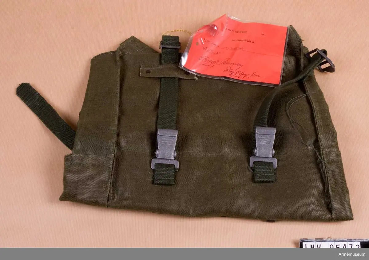 Vidhängande etikett: "Försvarets materielverk Originalmodell M 7390-301154-4, Ryggväska, 1985-09-30 (oläslig underskrift)".