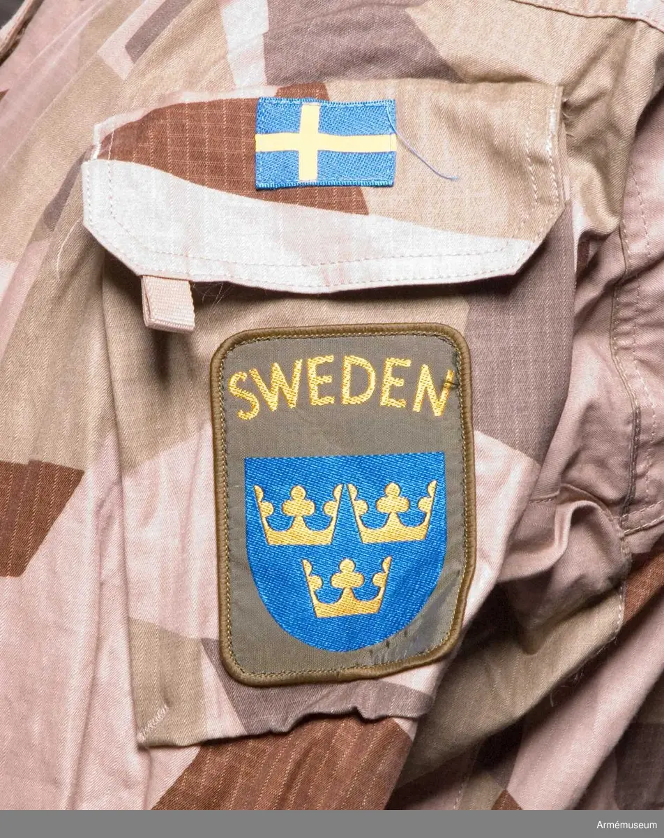 Utförd i ökenkamouflage.
På vänster ärm: Förbandstecken (Utlandsstyrkan) och Nationalitetsmärke.
Tillverkad 2007 i Kina.