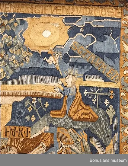 Bildvävnad från tidigt 1600-tal i lin, ull och hår. Flamskvävnad. Scener ur gamla och nya testamentet. I mitten Livets träd på vars vänstra sida återges scener ur gamla testamentet. På trädets högra sida den knäböjande jungfru Maria, Kristus på korset med omgivande bård, troligen efter försättsblad till tysk bibel 1500-talets förra hälft. Troligen nordtyskt arbete.


Ur handskrivna katalogen 1957-1958:
Gustavsbergstapeten
ÄVEN KALLAD GULLMARSBERGSTAPETEN.
DEPOSITION I APRIL 1947 AV GUSTAVSBERGS BARNHEM ENLIGT LAPPKATALOG. 242 x 205 cm.