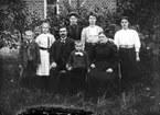 Familj framför tegelbyggnad, troligen 14 oktober 1909