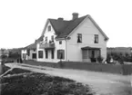 Stadsfiskal Elof Ström med familj vid bostaden, norra hörnet Torggatan - Västra Ringgatan, Enköping, vy från söder, troligen 25 augusti 1909