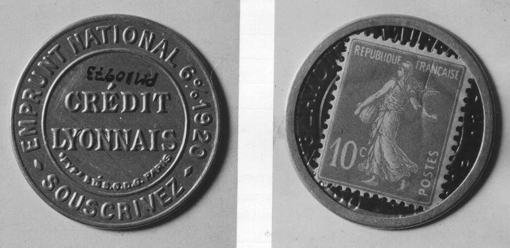 Frimärke 10 centimes i rund hylsa av aluminiumplåt
(liknandeen fickspegel). Framsidan genomskinlig (celluloid över
frimärket).Använt som skiljemynt i Frankrike efter första
världskriget.