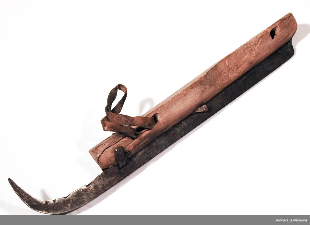 Ett par skridskor med fotstöd i trä, skena i smitt järn och läderremmar. 1800-tal.