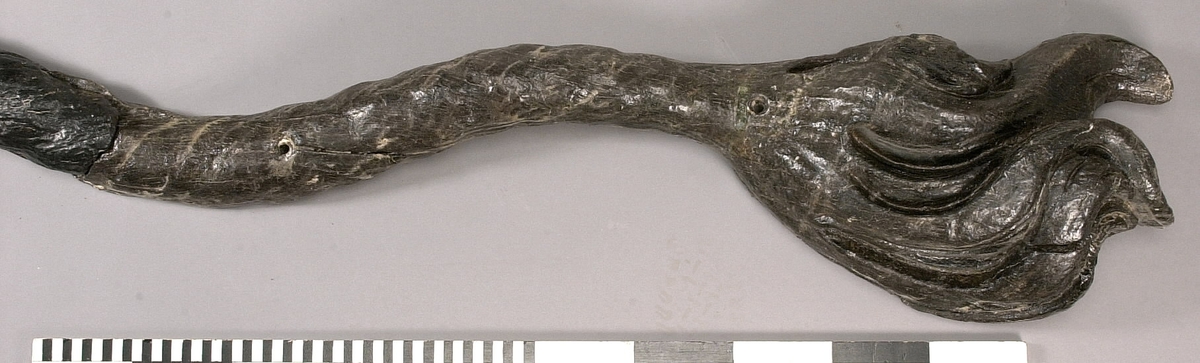 Skulpterad lejonsvans, lagad i rotändan. Svanstofsen är stor och yvig. Svansens baksida är slät.

Text in English: A sculpted lion''s tail, broken off where it was attached to the lion''s hind quarters. The tuft is large and bushy. The reverse side is smooth.