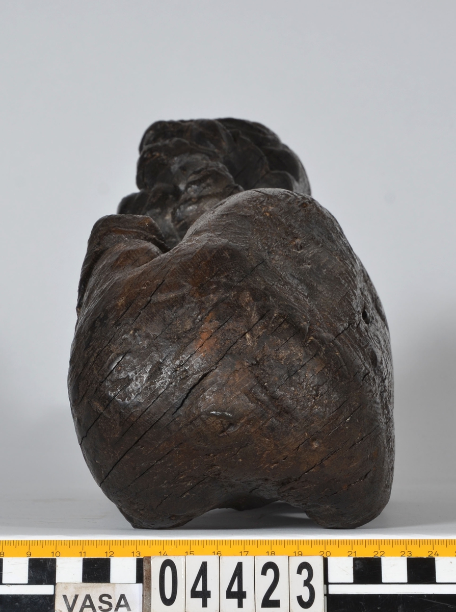Skulptur av ett litet, liggande lejon med utsträckta framben och hopdragna bakben.
Lejonet är riktat mot vänster, sett från betraktaren. Det snett hållna huvudet återges i det närmaste i en face. Större delen av svansen saknas. Den befintliga delen av svansen avtecknar sig mot lejonets vänstra lår.

Lejonet är endast delvist rundskulpterat. På baksidan, i höjd med huvudet och höger framben, återfinns ett stort, snett urtag som bildar en slät anliggningsyta. Skulpturens framparti är således endast till hälften så tjockt som dess bakparti.
Bakkroppen är kraftigt sliten och skadad. Vänster bakben saknas, liksom större delen av svansen.

Text in English: Sculpture of a small reclining lion with its forelegs extended and its  hind legs tucked beneath its body.
Facing to the observer''s left, the head, held crookedly, is nearly en face. A large part of the tail is missing, and the remainder curves towards the left hind leg.

The lion is only partly three-dimensional. On the rear at the head height and at the right foreleg a large oblique hole forms a flat area for attachement, thus the forepart of the sculpture is thus only half as thick as its rear.
The rear of the body is badly worn and damaged. The left hind leg has been broken off.