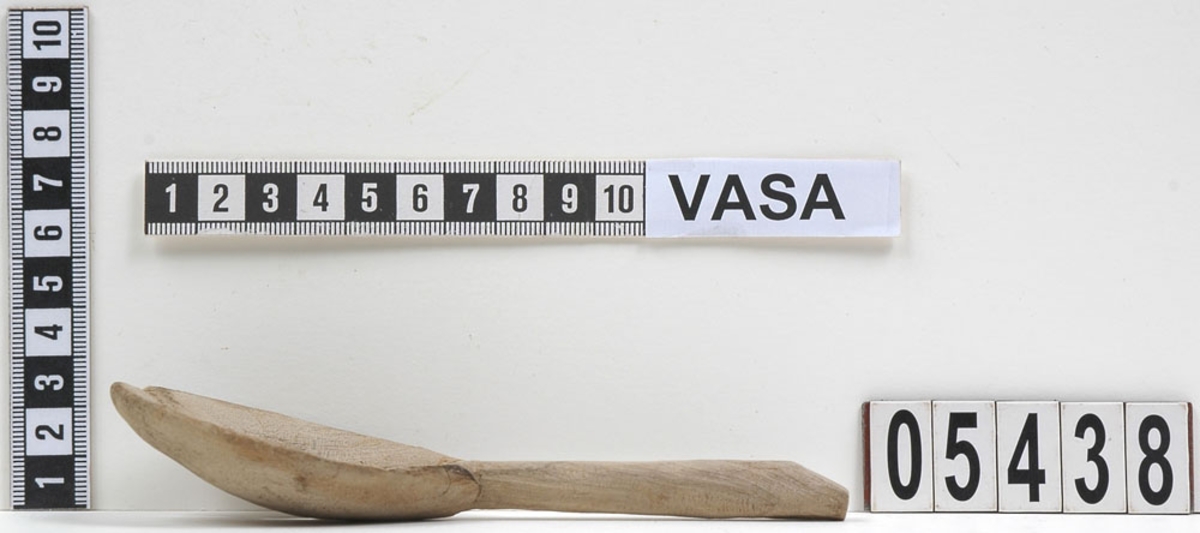 En träsked som tidigare var bruten i fyra delar. En av delarna utgör skaft samt mindre parti av skedblad. De tre övriga är delarna av skedbladet.
Idag är delarna sammanfogade och i sin helhet har skeden ett runt skedblad och ett rakt skaft där tvärsnittet är något ovalt.
Skeden är mycket ömtålig. Ett mindre parti av skedbladet saknas.