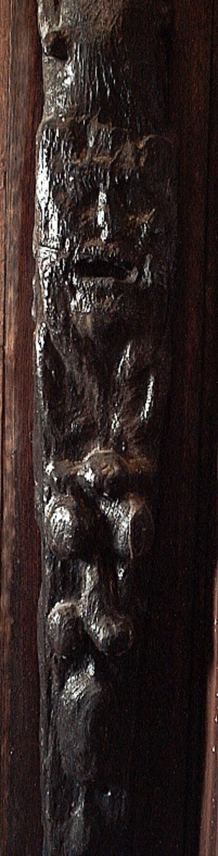 Skulpterad pilaster utformad som en karyatid med långt hår, troligen placerad under ett joniskt kapitäl.
Huvudet är vridet åt vänster. Höger arm är sträckt utefter sidan. Vänster arm är böjd och i handen håller figuren ett okänt föremål.
Pilasterskaftet är upptill prytt med en maskaron med bred, öppen mun och nedtill med en tung fruktfeston. Det nedåt avsmalnande pilasterskaftet avgränsas från piedestalen av en enkel vulst eller list med uppdragna kanter. Piedestalen är hög och jämnbred samt prydd med ett litet huvud och avslutas nedtill med en förtjockad bas. Skulpturens baksida är slät.
Skulpturen är kraftigt sliten och nött med finare detaljer utplånade.

Text in English: Sculpted pilaster with Caryatid with long hair under what is possibly an Ionic capital.
The head is turned to the left, the right arm is streched along the side, the left arm is bent and the hand holds an unknown object.
The shaft of the pilaster is decorated above with a mask with a broad, open mouth, below is a heavy festoon of fruit. The shaft tapers downwards and is divided from its pedestal by a simple torus or batten with drawn-up edges. The pedestal is high and even in width and decorated with a small head. It terminates at the bottom in a thickened base. Its back is smooth.
The sculpture is much worn, with finer details obliterated.