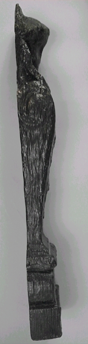 Liten skulpterad pilaster, utformad som en karyatid eller möjligen en putto. Figuren har långt hår och ett knubbigt ansikte, omgivet av en bred krage. Det nedåt avsmalnande pilasterskaftet är dekorerat med akantusblad. Nedtill avslutas pilastern av en rikt profilerad och dekorerad sockel. Skulpturens baksida är slät.
Skulpturen är sliten, främst den övre delen.

Text in English: A small carved pilaster, with a caryatid or probably a putto. The figure has a chubby face, long hair and a broad collar. The lower part of the pilaster is decorated with acanthus leaves. The caryatid stands on a richly profiled and decorated socle. The back of the sculpture is smooth.
The sculpture is worn.