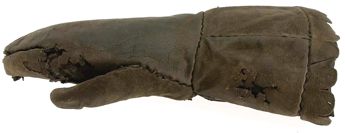 En kragvante till höger hand. Sydd av flera kraftiga läderstycken. Påsydd bård i ett stycke i form av rundade "tungor" längs kragkanten.