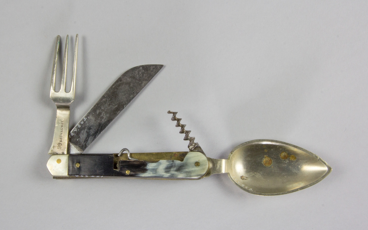 Bestick, fällkniv med handtag av horn och knivblad av stål, sked och gaffel av försilvrad metall, samt dessutom korkskruv och handskknäppare. Signerad: '59 Sauvagnat'.