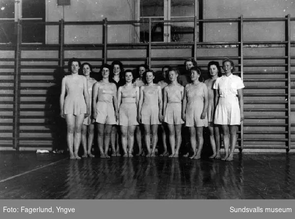 Kvinnlig gymnastikgrupp i gymnastiksal i Vapelnäs, Njurunda. T h ledaren Carla Magnuson.