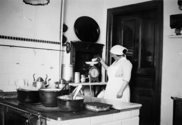 Hilma Olsson arbetar i köket och mäter upp något på en våg i