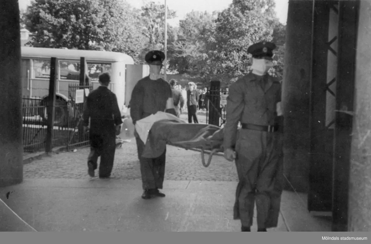"Karantänsförläggning" på Kvarnbyskolan för överlevande från koncentrationsläger i Tyskland och Polen 1945.  
Skolan fungerade under denna sommar som beredsskapssjukhus

Flykting som blir inburen på bår av Röda Kors personal.