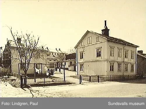 Nygatan 19. Fastigheten uppfördes 1895 av handlaren MAFürst som även där bedrev handelsrörelse(speceriaffär) i det tillhörande huset.Byggnaderna är uppförda av timmer som spönats.1901 sålde Fürst fastigheten till torparen ErikAugust Sjölund som innehade densamma ett par år varefter Fürst åter fövärvade egendommen. 1907 övertogs fastigheten av inspektoren  på Rosenborg,  A.J Berg. Rörelsen drevs fram till första världskriget av fru Johanna Berg.I gårdshuset inrättades en elektrisk mangel,som efter båda makarnas frånfälle övertogs av en dotter och som alltjämt var i full verksamhet. t.o. m. 1960 då även denna nedlades.