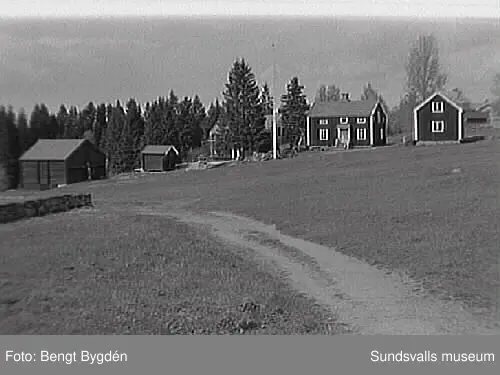Nya och gamla kyrkan på Alnö, kyrkskolan, hembygdsgården samt intilliggande bebyggelse.