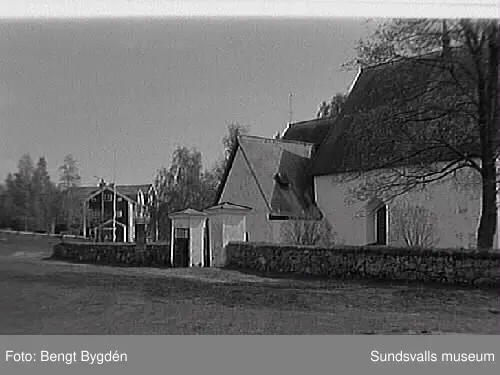 Nya och gamla kyrkan på Alnö, kyrkskolan, hembygdsgården samt intilliggande bebyggelse.