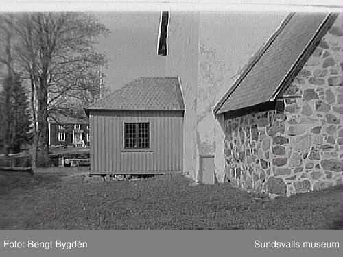 Nya och gamla kyrkan på Alnö, kyrkskolan, hembygdsgården samt intilliggande bebyggelse.