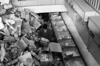 Paketsorteringsmaskin å huvudpostkontoret i Kyoto, Japan. 
Foton 21/12 1962.  Från grovsorteringen.  Påläggning av paket på
brickorna.