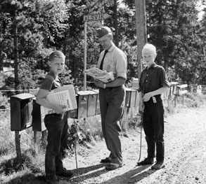 Bilåkande lantbrevbäraren Erik Johansson på linjen Åkersberga - Singö - Björnhuvud - Åkersberga. Lantbrevbärare Johansson lämnar post vid brevlådesamlingen i Alsvik.

Foton augusti 1961.