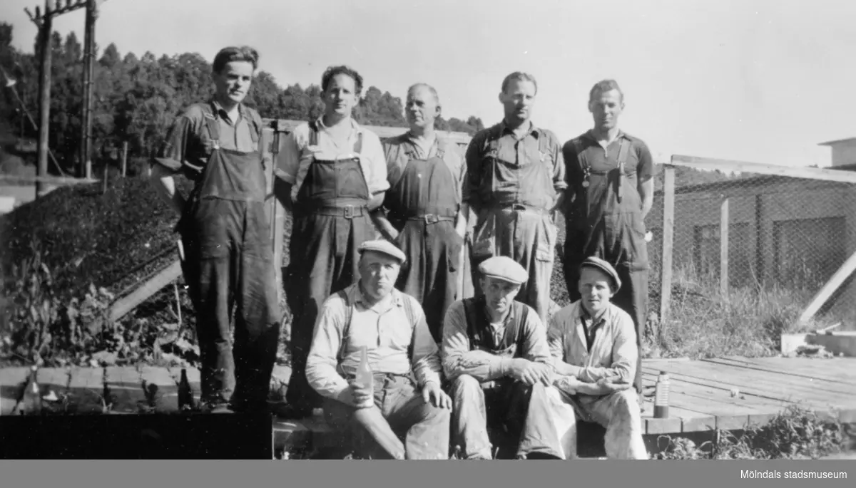 Arbetare som troligtvis ingick reparationsgruppen står uppställda utanför färgeriet på August Werners fabriker, cirka 1940- till 50-talet.
Arvid Svensson som sitter längst till höger var murare. Eklund som står till vänster var eldare. Från vänster står Albert. Bakre rad från vänster står Eklund.