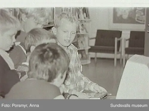 Dokumentationsfotografering av verksamheten vid biblioteksfilialen i Matfors. Bild 01Biblioteksassistenten Ingrid Engström, Matfors bibliotek, med låntagare vid utlånedisken. Bild 09 bibliotekaren Inger Barkman läser för en grupp förskolebarn i bibliotekets "läsrum".
