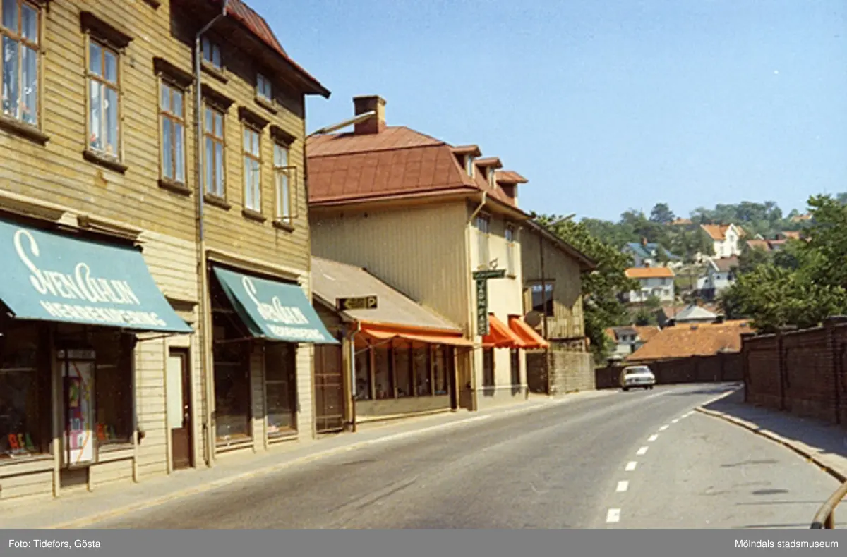 Kvarnbygatan 25-27, 1960-tal. Husen låg mitt emot Papyrus port. Till vänster ses Sven Ahlin Herrekipering ("Frituna" på Kvarnbygatan 25). Husen är idag rivna.