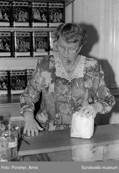 Kaffeaffären IDO, Nybrogatan. Bildsvit gjord för dokumentation utförd 1996. Affärsrörelsen grundades av Carl Dahlström den 18 november 1931. Dahlström föddes i Närsta, Alnö. Han arbetade som kassör på Hörningsholms sågverk 1918 till 1930 då sågen lades ner. Han fick inspirartion att starta kaffehandeln av sin bror Erland som arbetade på Kolonialvaruaktiebolaget. Mellan 1931 till 1937 drev Dahlström kaffehandeln tills en anställd, Eva Farm, tog över som nästa ägare. Sune Bäckström som tidigare arbetat som springpojke på firman tog över verksamheten 1954. Rosteriet som tidigare låg i magasinskvarteren (nuvarande Kulturmagasinet) flyttades 1983 till innergården vid Blombergska huset och en specialbyggd skorsten fick uppföras. Tonvikten på försäljningen ligger numera (2020) på ett välsorterat utbud av olika tesorter.