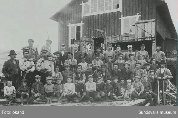 Personal vid Juniskärs sågverk. Mannen i vit vegamössa mitt i bakre raden är platschefen Jacob Jensen från Norge.