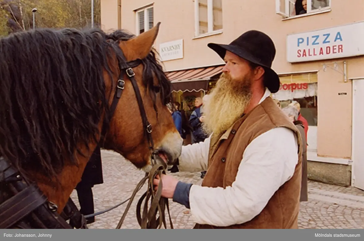 Gamla torget i Mölndal den 22:a november 2001. 
En kusk håller en arbetshäst i selen.
Invigning efter omläggning och stenläggning av torget.