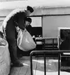 Chaufförerna Nils Gunnar Jonsson,t.v., och Gustav Jarneving lastar
in post i en rälsbussfinka på Eskilstuna C., vid middagstid.