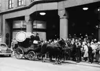 Postiljon Tore Steger tutar i posthornet framför NK. Postmuseums
hästdiligens gjorde postturer mellan NK och postkontoret Stockholm 1.