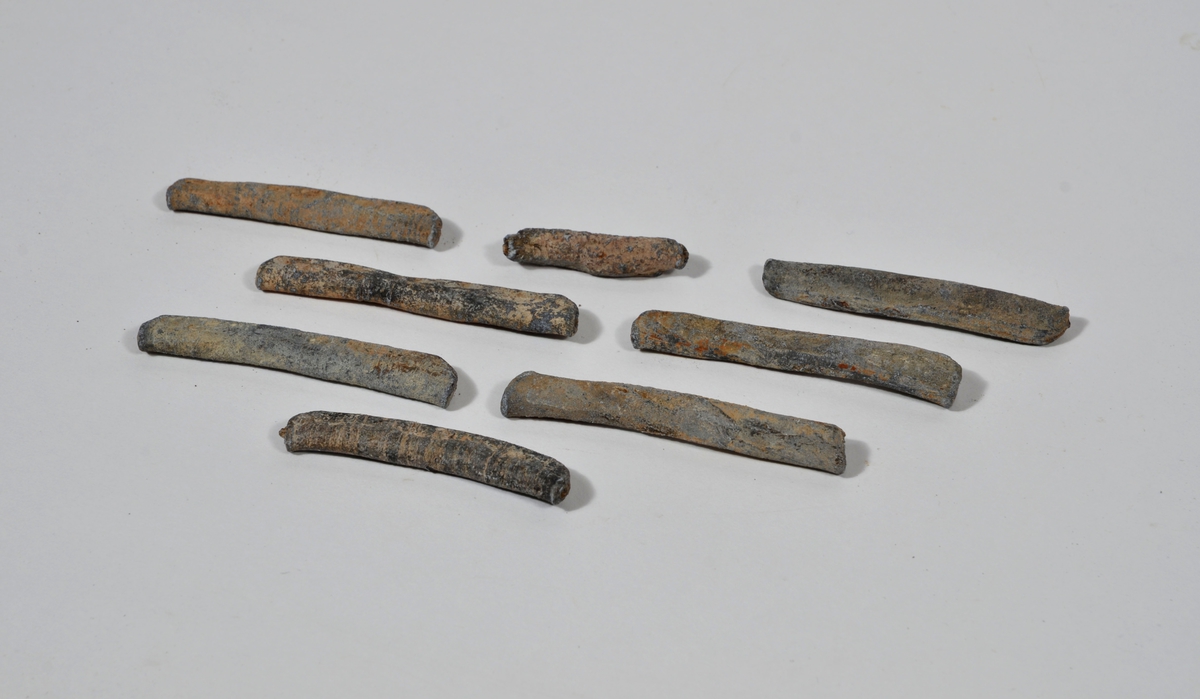 Sänket består av vikt blybit. Sänket har tydliga märken efter det verktyg som pressat ihop sänket runt garntråden. Sänket är i gott skick.

Text in English: Lead sinker in the shape of a flat tube. The rectangular piece of lead is folded vertically in half and has visible tool marks from the folding process. The yarn is pushed through the hole. Grey mat in colour. In good condition.