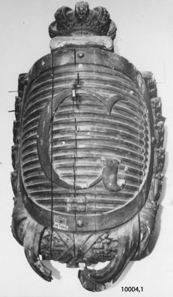 Galjonsbild från ångkorvetten Gevle.
Utgöres av vapensköld av trä, gråmålad, med horisontala räfflor samt bokstaven G.
Skölden krönt med en kunglig krona på kudde och omgiven av eklövskrans med band.