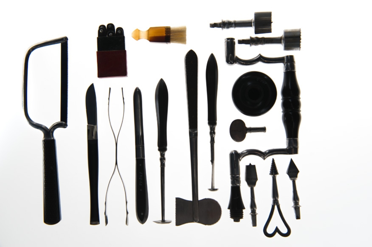 Helt fodrad invändigt med röd sammet och med löst innerfack av mahogny. Till kistan hör ett löst läderfodral märkt N:o 1.
Kistan är tillverkad av C.F. Ponsbach, kirurgisk instumentmakare vid Kungl. Karolinska Institutet, Kungsholmen, Stockholm, åren 1830-35. Samtliga instument är signerade "Ponsbach" och i locket på kistan finnes en tryckt etikett av äggrund form med texten : "TILLWÄRKAS af C.F. PONSBACH Chirurgisk Instumentmakare i Stockholm, Kongl. Carolin. Istitut. på Kongsholmen."

Kistan är försedd med lås och nyckel. Den har tillhört sjukvårdsutredning ombord för kanonjoll och varit förvarad å Sjukhusförrådet, Örlogsvarvet i Stockholm (1938).

Samtliga instrument är väl utförda och omfattar:
1/ Amputationskniv, 190 mm lång, med oval spets och
refflat svart träskaft.
2/ Amputationskniv, 160 mm lång, med oval spets och
refflat svart träskaft.
3/ Kniv med lancettspets, 130 mm lång med refflat svart
träskaft.
4/ Kniv med lancettspets, 93 mm lång med refflat svart
träskaft.
5/ Avbitaretång, helt i stål, 164 mm lång.
6/ Kulutrdragaretång, helt stål, 205 mm, med skaftet refflat.
7/ Tandtång, helt stål, med skaftet refflat, 130 mm lång.
8/ Tandtång, helt stål, med skaftet refflat, 135 mm lång.
9/ Tandnyckel, 150 mm inklusive polerat mahognyskaft.
10/ Lös krok till ovanstående tandnyckel, 25 mm, helt stål.
11/ Lös krok d:o    d:o    d:o    d:o    d:o
12/ Bensåg av fogsvanstyp, längd 260 mm, med mahognyskaft.
13/ Benskruv med ringformat handtag, 120 mm lång, helt stål.
14/ Munspatel med två skedblad, helt stål, 190 mm lång.
15/ Pincett av stål med lås, 90 mm.
16/ Fingersåg, 10 cm, med svart refflat träskaft.
17/ Operationsnålar, böjda, 12 st, för sutur.
18/ Troikar med kanyl, 82 mm, med svart polerat träskaft.
19/ Troikar med kanyl, 74 mm, d:o    d:o     d:o
20/ Lancett dold i benskaft, 110 mm lång, böjd.
21/ Geissfuss (getfot), 90 mm lång m. polerat skaft (tandutdragn.)
22/ Sax, rak, osignerad, ny, 150 mm.
23/ Bindtyg av brunt läder med tre små lancetter i svart benskaft.
24/ Tournikett-läderbitar, 60 x 80 mm, ljust läder.
25/ Pelott, kudde av kork, klädd med sämkinn, 40 x 60 mm.
26/ Artärnål, 70 mm, med brunt polerat träskaft.
27/ Fodral av mahogny med 5  skalpeller, en pincett och en liten
stålkrok (dissektionsbestick).
28/ Etui, litet, av rött läder med 6 st små lancetter i sköld-
paddskaft. Lancetterna märkta med ?C.F.P.?
29/ Trepanborr, rund, sågtandad, helt stål med pistill i mitten.
30/ Trepanborr, refflad  d:o    d:o   d:o   d:o
31/ Trepanborrsväng med skaft av polerat svart trä.
32/ Knapp till ovanstånende av   d:o   d:o
33/ Pistillnyckel till trepanstiftet.
34/ Trepanborr (spetsborr), helt stål.
35/ Tirefond, skruv för att draga ut benstycket vid trepanering.
36/ Trepanborr (tappborr), helt stål.
37/ Culter lenticularis med svart polerat skaft.
38/ Brosåg, tvåeggad, 35 mm, med svart polerat skaft.
39/ Raspator vinkelform, med skaft av polert trä, för att
bortskrapa benhinnan - periostet - vid trepanering.
40/ Benfil, längd 140 mm, med svart polerat skaft.
41/ Pincett, dubbel, helt av stål, längd 170 mm.
42/ Skalpell, rak, med polerat träskaft.
43/ Trepanborste i liten hornhylsa.
44/ Operationstråd på rulle, rött silke.
45/          D:o        d:o  oblekt linnetråd.
46/ Vaxbit till ovanstånde tråd.
47/ Ters av svartbetsat trä med märling, längd 120 mm.
48/ Ters  d:o   d:o   d:o       d:o     d:o
49/ Ters   d:o    d:o    d:o   d.o
50/ Tournikett av mässing med spärrhake, utan band.
51/ Tournikett   d:o     d:o      d:o      d:o
52/ Bindtyg av brunt läder innehållande lancetter i benskaft,
rakkniv, snabelsax, peang.
53/ Matstrupsintrument, liten svamp på smalt skaft av val-
fiskben.
54/ Bougier, kaustika, i papperfodral.
55/ Katetrar och sonder av gummi.
