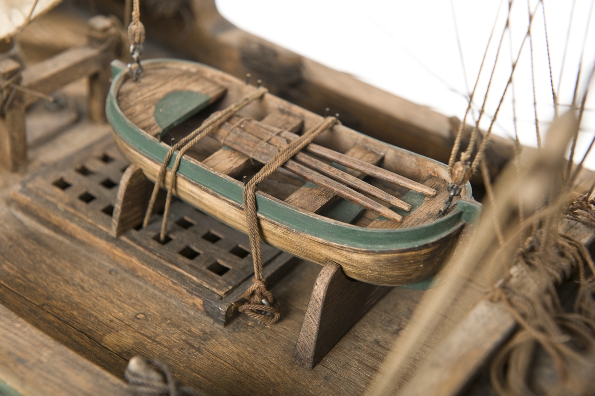 Flöjtskeppsmodell. Riggat med stående och löpande gods, segel av bomull. Bogspröt m. 2 blindor. Fock- o stormast med märs- och undersegel. Latinsegel på mesanmasten. Galjon m. lejon. 2 bogankare, båt på skrå midskeppsöver storluckan. På halvdäck 2 metallkanoner, 4 bogkanoner, samt 4 kanoner på låringen. 1 campagnelykta. Mörkbetsat skrov med 2 svarta berghult, svart bottenfärg. Akterspegel rikt ornerad med 6 fönster. Föremålets form: Helmodell