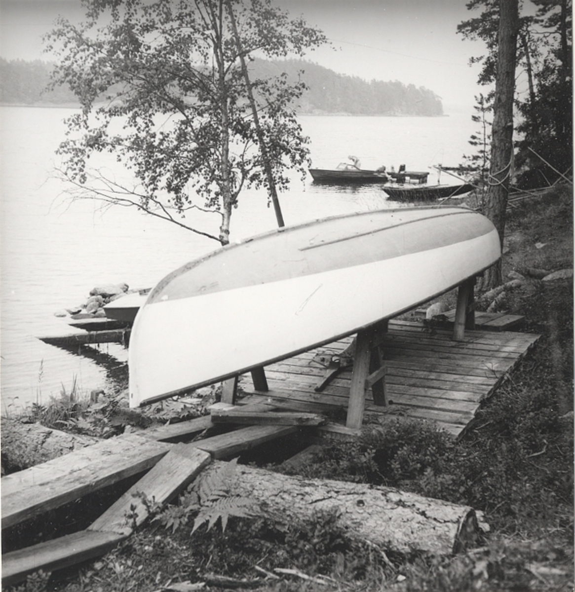 Segelkanot, klass III B, med Güntherrigg och centerbord. Fall, skot och block saknas. Byggd i mahogny, furu och duk. 
Vita fribord och gult däck. Mittfiskar och sarg i mahogny.