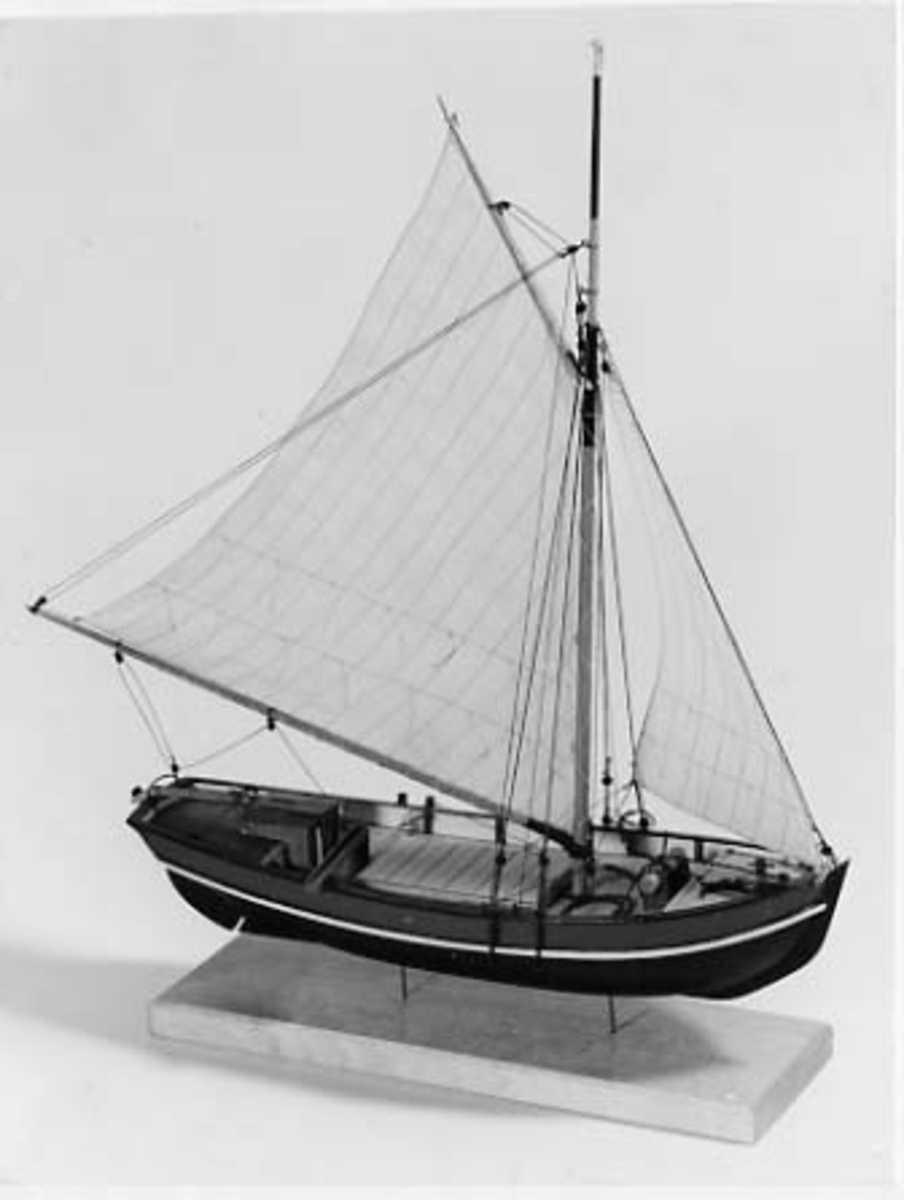 Riggad med fock och gaffelstorsegel. Svart skrov, grön bredgång. Vit kaltopp. Modellen tillverkad till utställningen "Seglande kungar, kungliga seglare", KSSS 150-årsjubileum 1980.