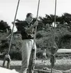 Ole Crumlin-Pedersen står på relingen vid vanten. Imme Gram under segling i Lilla Bält.