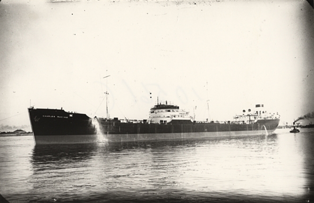 Foto i svartvitt visande tankmotorfartyget "CHARLES RACINE" av Stavanger under bogsering i Köpenhamn under slutet av 1930-talet.