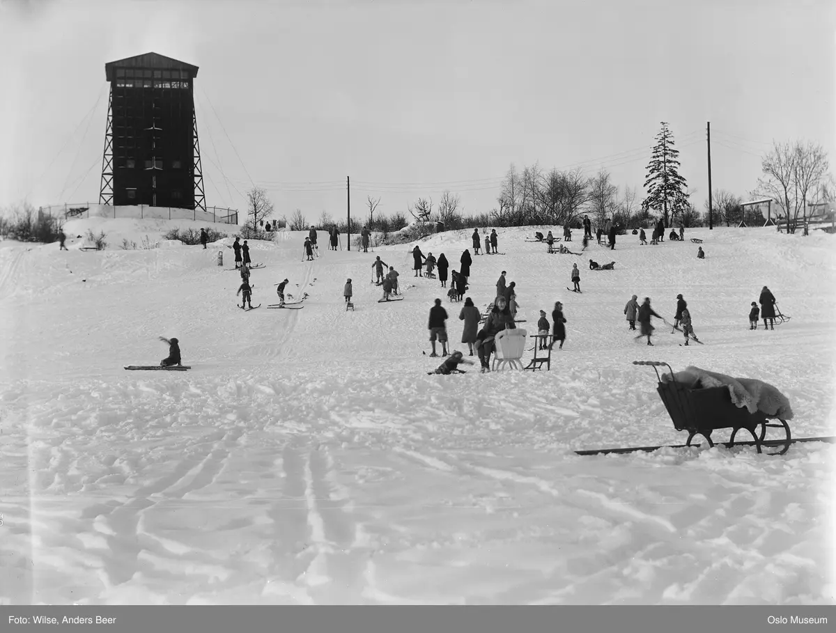 park, hus rundt Monolitten, snø, barn, voksne, lek, ski, kjelker, sparkstøttinger