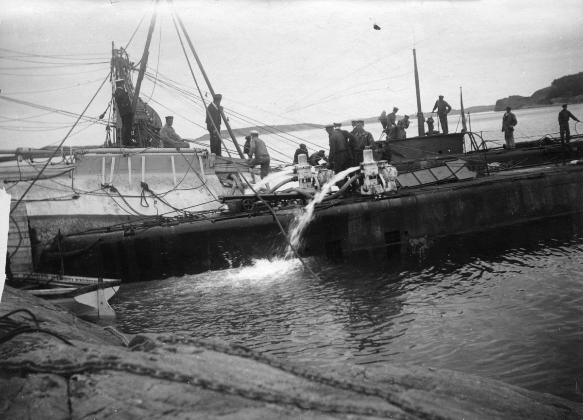 Sjömän i fart med att pumpa ut vatten ur den kapsejsade båten "Falken" 1917.