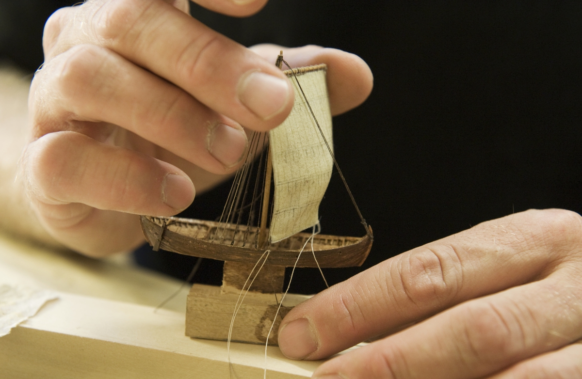 Modellbyggare Stefan Brun i arbete med en modell i skala 1:200 till utställningen "Shipping & Shopping".