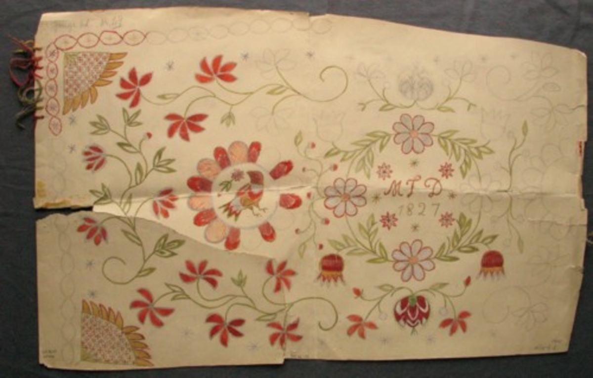 Målad skiss på styvt papper. Del av agedyna. Krans av blommor och blad i mitten med monogram mitt i: MID 1827. Vid sidan av kransen stor blomma med en fågel i mitten, i hörnen sorlosor. Mellan solrosorna finns kvistar med blommor. Bården är en flätkrans med en enkel stjärna i. Två olika uppsättningar garnprover, en på varje kortsida.  Gammal märkning: "Nr 29 Göinge hd".