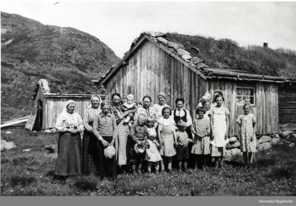 Stølsfolk på Dokkstølen 71/3 i Holdeskaret i Hemsedal i 1940.
Frå venstre: Guri Holde, Ingebjørg Møllerplass, Oskar Holde, Margit Dokk med Maria, Bjarne Holde, Torbjørg og Borghild Flaget. 
Bak desse: Karoline Holde, fru Eriksen, Gudrun Dokk, Torkild Flaget, Margit Fekene (i stakk), Anne og Magnhild Flaget, Birgit Dokk, Tora Flaget, bak Margit Flaget med Magne Flaget.