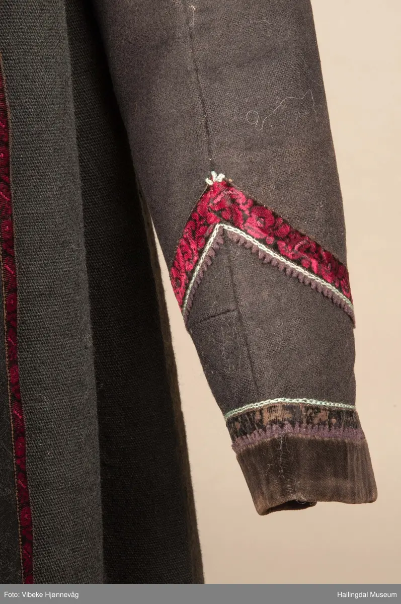 Kone fra Øvre Hallingdal i hallingbunad.  Hun bærer hette.  Kona står utstilt i den faste bunadutstillingen på Hallingdal Museum, Nesbyen.  Hallingbunaden består av mange draktdeler; trøye, Forkle HFN 02033, stakk, hette, silketørkle i halsen, perlet bringduk el. brystklut og skjorte.