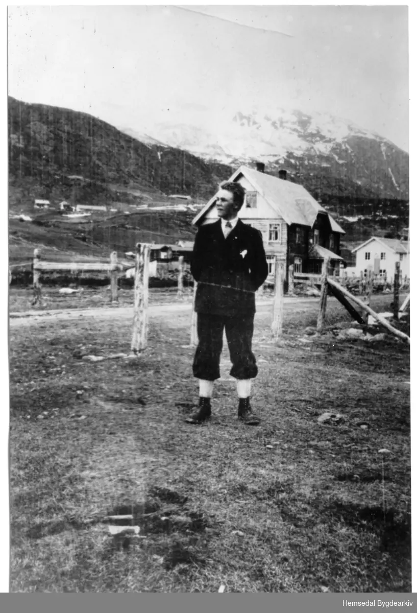 Olav E. Fekene på Bakka framfor Lassestugu. I bakgrunnen det gamle hotellet Fjellheim.