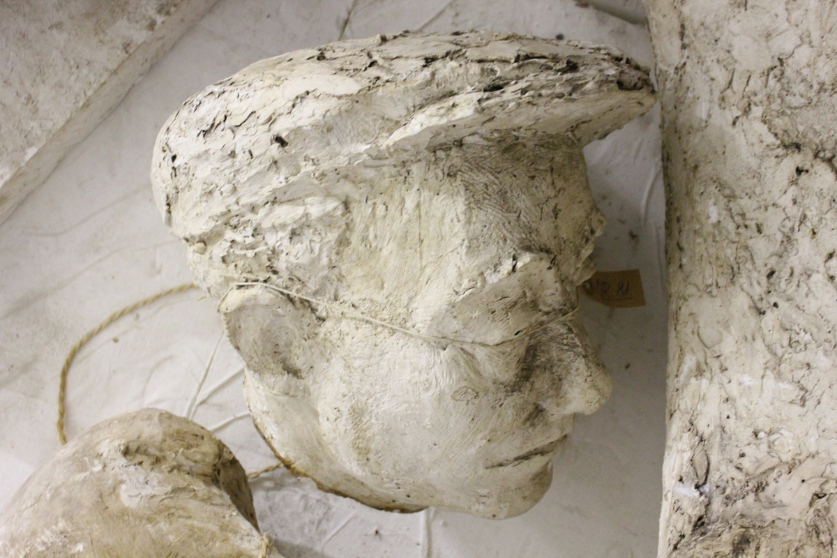 Skulptur i gips i full størrelse av et hode. Tittel: "BRYGGESJAUEREN". Skulpturen i bronse står i Drammen Se nr.276