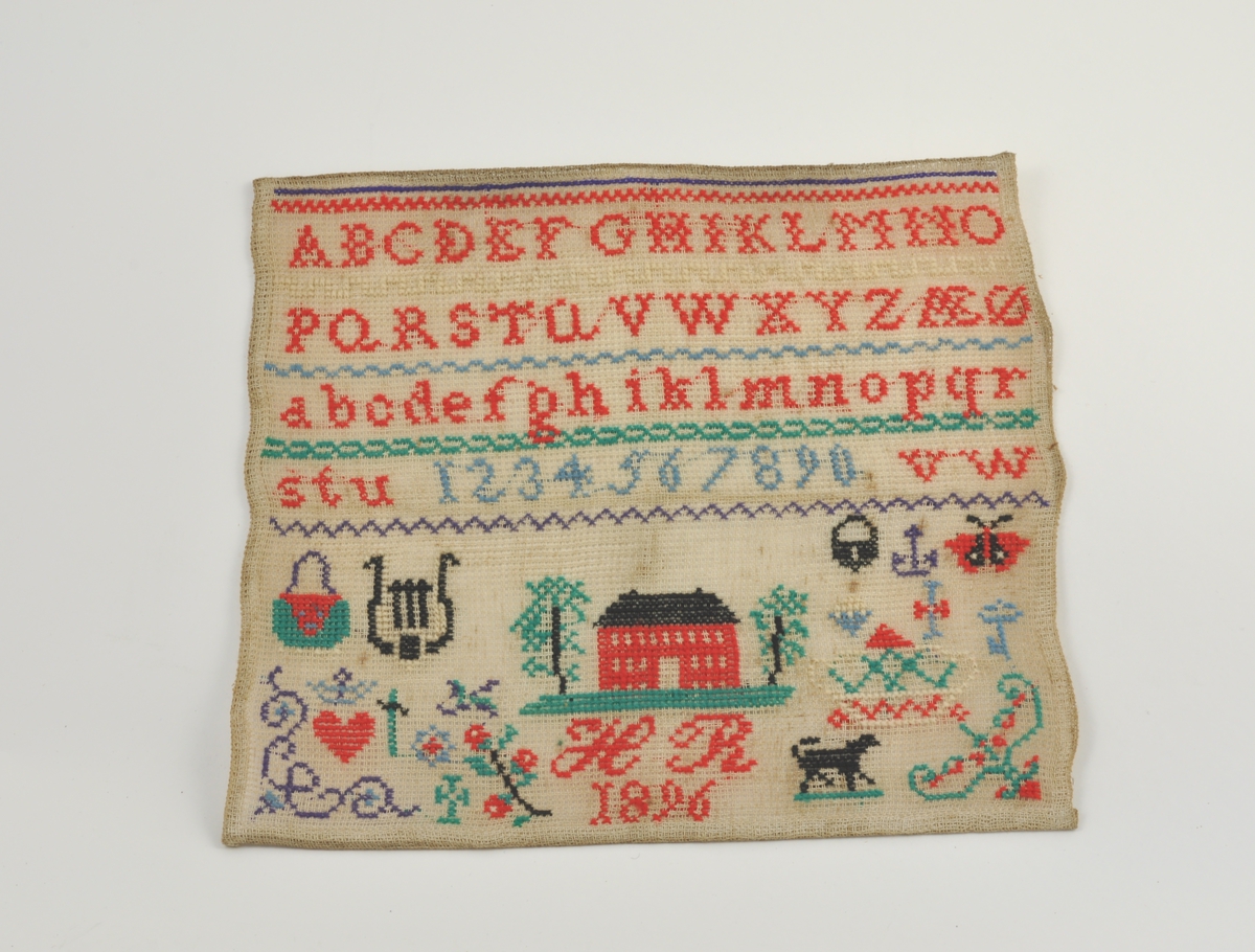 Navneduk fra 1896. Korssting på stramei. Navneduken er rammet inn med glass og ramme på et senere tidspunkt.