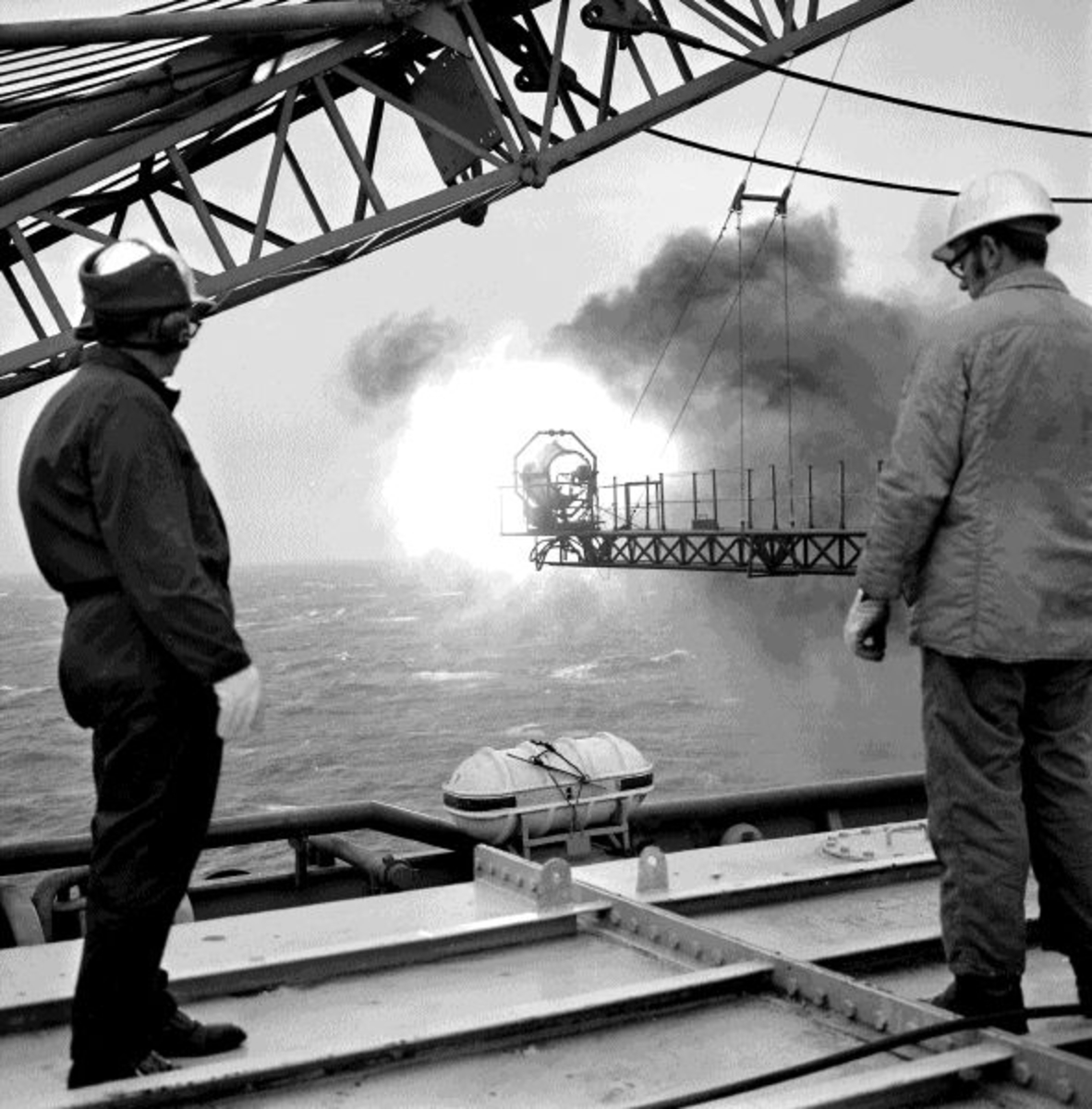To menn studerer en flammebom på boreplattformen "Gulftide".